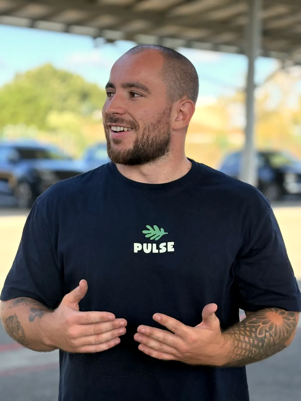 Florent, coach de Pulse, en t-shirt Pulse sous le préau