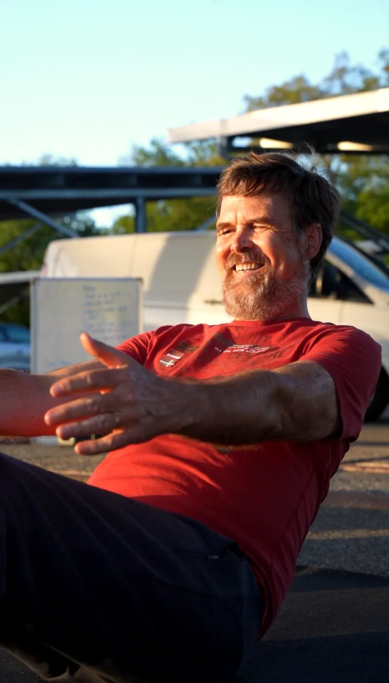 Un participant rit pendant un exercice de gainage